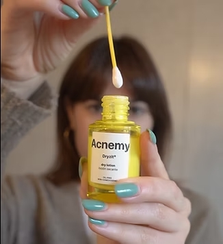 Mujer sostiene un bote de producto de la marca Acnemy